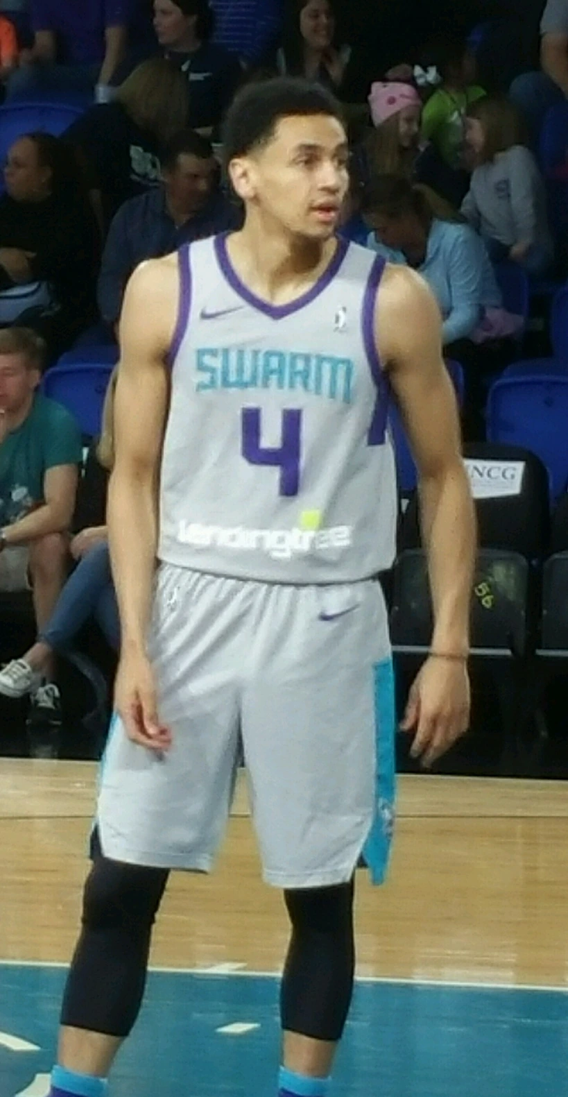 Marcus Paige in a basketball uniform standing on the court during a game.